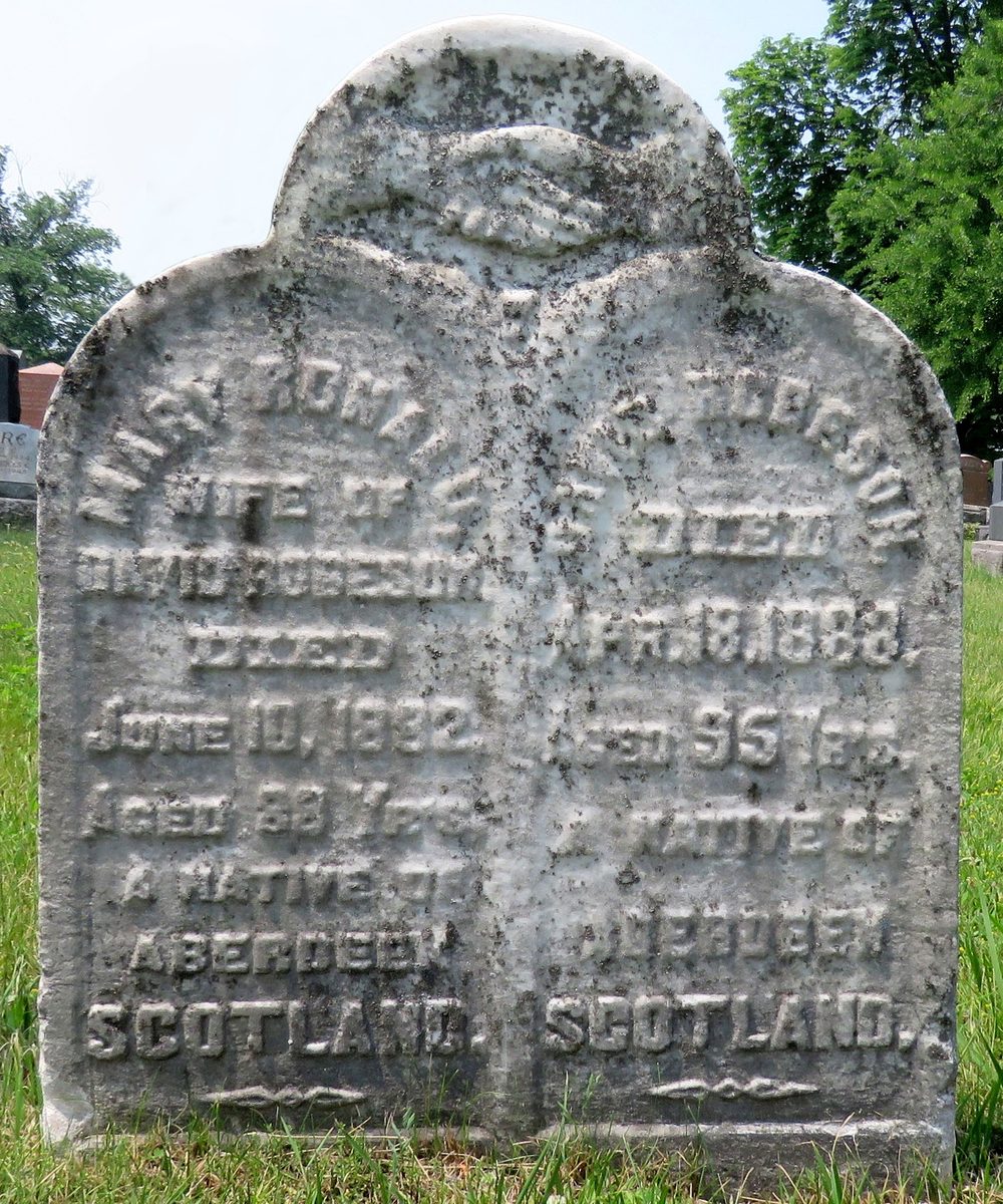 Weathered marble headstone with clasped hands, for Mary Ronald wife of David Robeson and David Robeson, both natives of Aberdeen, Scotland